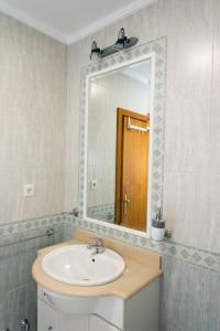 uma casa de banho com um lavatório e um espelho em Paulo Guest Apartment nas Caldas da Rainha