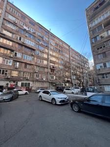 a parking lot with cars parked in front of a building at Pushkiin in Yerevan