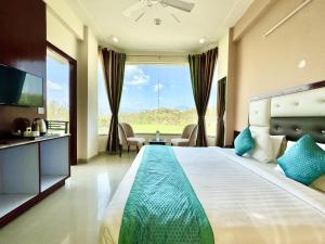 ein Schlafzimmer mit einem großen Bett und einem großen Fenster in der Unterkunft Sumedha Resort & SPA Rishikesh in Rishikesh
