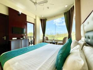 瑞詩凱詩的住宿－Sumedha Resort & SPA Rishikesh，一间卧室设有一张大床和大窗户