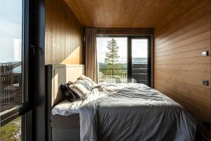 1 dormitorio con cama y ventana grande en The Riverside Mountain Lodge - 110sqm of Calm Luxury en Idre