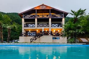 a house with a swimming pool in front of it at Pensiunea Decebal Resort - Cazanele Dunarii in Dubova