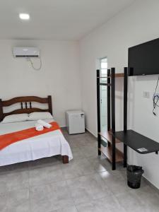 a bedroom with a bed and a black desk at Pousada Vila Real PG in Praia Grande