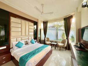 a bedroom with a large bed and a television at Sumedha Resort & SPA Rishikesh in Rishīkesh
