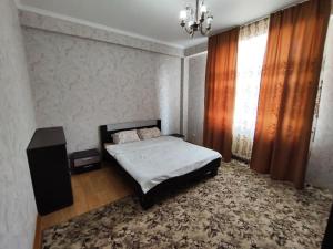 - une chambre avec un lit, une table et une fenêtre dans l'établissement Квартира в районе Океан!, à Bishkek