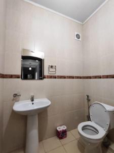 La salle de bains est pourvue de toilettes et d'un lavabo. dans l'établissement Квартира в районе Океан!, à Bishkek