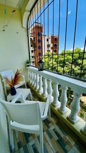 d'un balcon avec une balustrade blanche, des chaises et une fenêtre. dans l'établissement Unique apartment 2, à Mombasa
