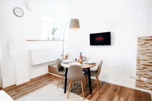 BackHome - Fantastische Schlosslage, SmartTV, Netflix, 50qm, 24h Checkin - Apartment 1 في لودفيغسبورغ: غرفة طعام مع طاولة وكراسي