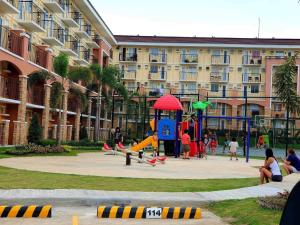 un parque infantil frente a un gran edificio de apartamentos en Arezzo Davao GZJ condotelle 300mbps wifi en Davao