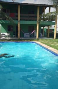 uma piscina com um baloiço em frente a um edifício em Casa de Praia na Tabuba-Ceará em Caucaia
