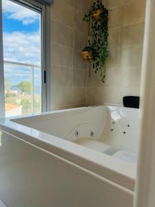 a white bath tub in a bathroom with a window at Apto. Burbujas - Marenia´s Dream in Denia