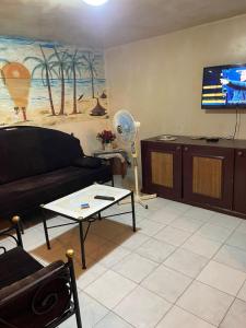 a living room with a couch and a tv at Studio in Mbour