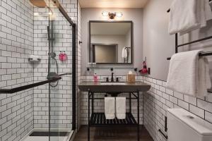 ein Bad mit einem Waschbecken und einem Spiegel in der Unterkunft Moxy Columbia Downtown in Columbia