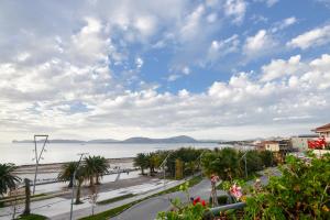 uitzicht op het strand vanaf het balkon van een gebouw bij Luxury Garibaldi in Alghero