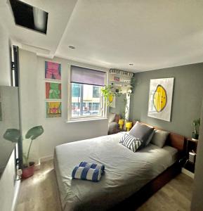 a bedroom with a bed and two windows at The Hoxton Nest - Shoreditch in London
