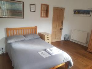 1 dormitorio con 1 cama y suelo de madera en One Home, en Oxford
