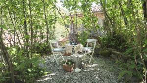 einen Tisch und Stühle in einem Garten mit Bäumen in der Unterkunft Casale Amati Country House in Ortonovo