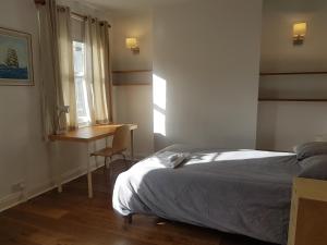 a bedroom with a bed and a desk and a window at One Home in Oxford