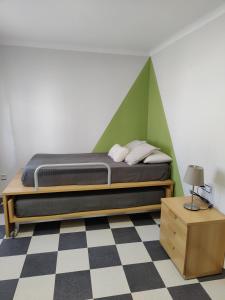 1 dormitorio con 1 cama con pared verde en Casa Baire, en Puigmoreno