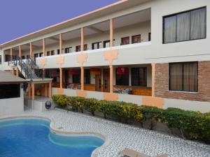 una vista exterior de un hotel con piscina en Hotel Garant & Suites en Boca Chica