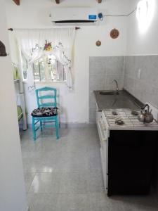 a kitchen with a blue chair and a sink at Cabaña el rincón de Termas in Termas de Río Hondo