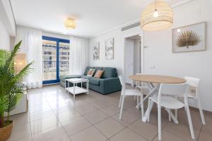 a living room with a table and a couch at ApartUP Patacona Infinity in Valencia