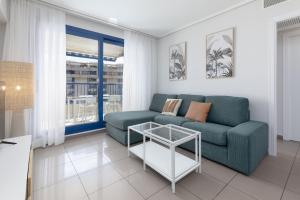 a living room with a couch and a table at ApartUP Patacona Infinity in Valencia