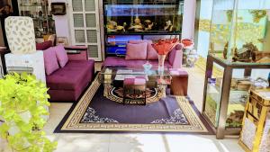 a living room with purple couches and a table at HT Hotel Apartment in Ho Chi Minh City
