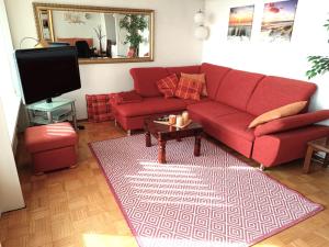 a living room with a red couch and a tv at Panoramic App A07-6 in Sierksdorf