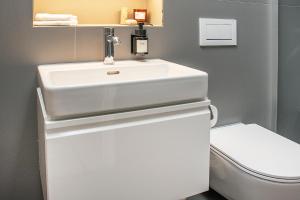 ein Badezimmer mit einem weißen Waschbecken und einem WC in der Unterkunft ※Luxus Loft mit Boxspringbetten und Heimkino ※ in Inzlingen