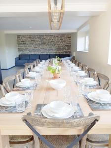 a long table with chairs and plates and glasses at Le Repos du Clocher in Daverdisse