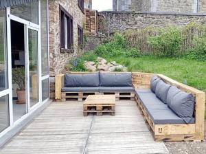 a wooden patio with a couch and a coffee table at Le Repos du Clocher in Daverdisse