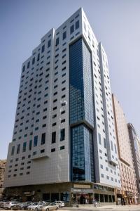 فندق بركة برهان في مكة المكرمة: مبنى طويل وبه سيارات متوقفة أمامه