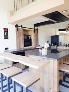 a large kitchen with wooden tables and benches at Le Repos du Clocher in Daverdisse