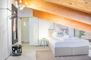 um quarto com uma cama branca e um tecto de madeira em ※Luxus Loft mit Boxspringbetten und Heimkino ※ em Inzlingen