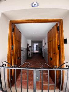 un pasillo con puertas de madera en una casa en Shanti’s Andalusian Rooms en Málaga