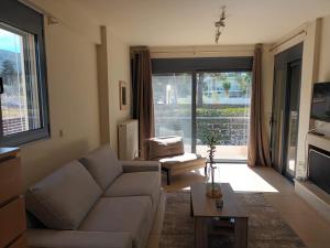 a living room with a couch and a table at Pool apartment 5 minutes walk from beach in Porto Rafti
