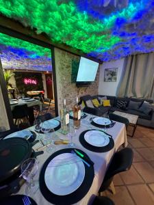 ein Esszimmer mit einem Tisch mit Tellern und Weingläsern in der Unterkunft PERLE RARE - Villa 4 chambres - Famille - Amis - Anniversaires - soirées in Vallauris