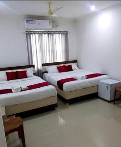 a bedroom with two beds and a window at Tharavad Residency in Iritti