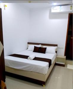 a bedroom with a large bed with brown and white pillows at Tharavad Residency in Iritti