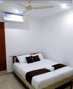 a bedroom with a large bed with white and brown pillows at Tharavad Residency in Iritti