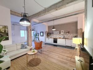 4 Dormitorios 5 baños Puerta de Toledo - Madrid في مدريد: غرفة معيشة مع أريكة ومطبخ