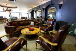 uma sala de estar com um sofá, cadeiras e uma mesa em Funda Hotel em Trabzon