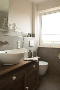 a bathroom with a white sink and a toilet at Ferienwohnung Auszeit Löningen in Löningen