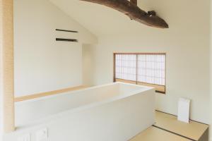 Habitación con paredes blancas y ventana grande. en Une stay&diner en Sasayama
