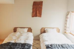 dos camas sentadas una al lado de la otra en una habitación en Une stay&diner en Sasayama