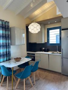 a kitchen with a table and some blue chairs at Summer Sea Verde Blu Apt in Corfu Town
