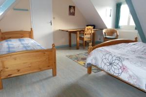 a bedroom with a bed and a table and chairs at Maison pour familles et amis in Dinard