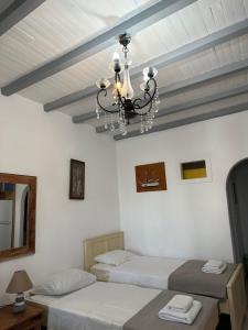 a bedroom with two beds and a chandelier at Harry’s studio in Naousa