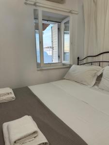 a bedroom with a white bed with a window at Harry’s studio in Naousa